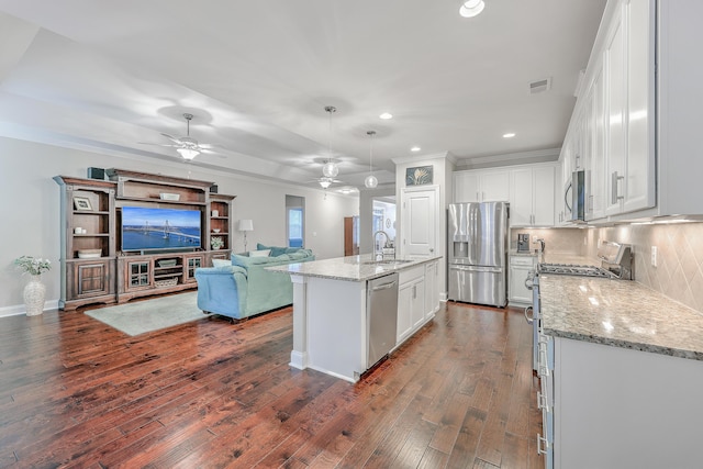 kitchen with white cabinetry, appliances with stainless steel finishes, a kitchen island with sink, and pendant lighting