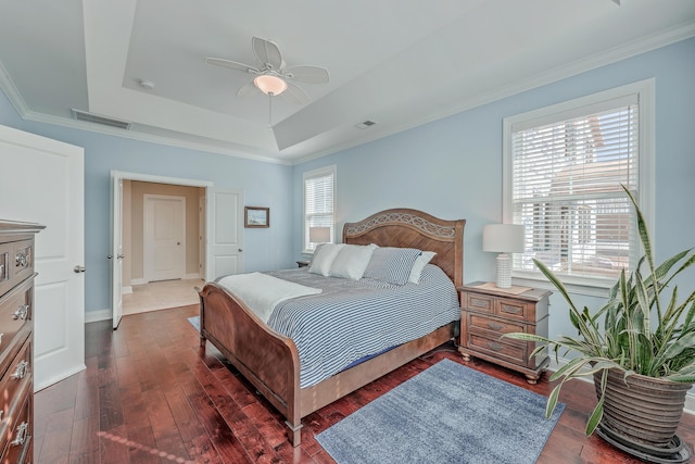 bedroom featuring crown molding, dark hardwood / wood-style floors, a raised ceiling, and ceiling fan