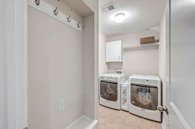 laundry area with cabinets, light tile patterned flooring, and washer and dryer