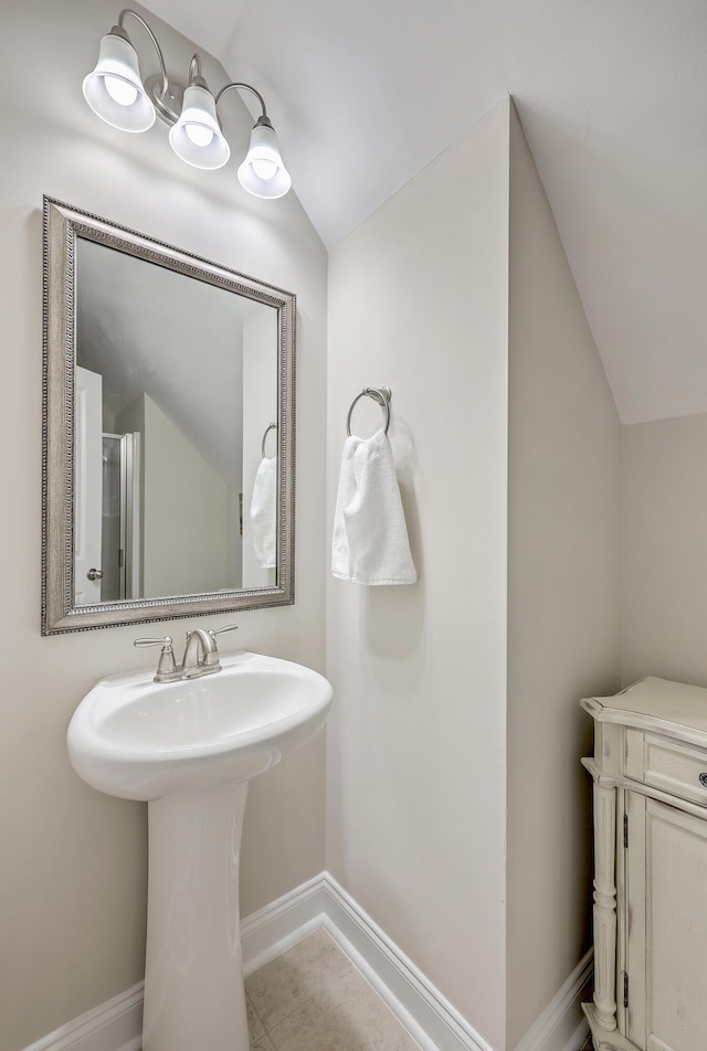 bathroom with tile patterned flooring and vaulted ceiling