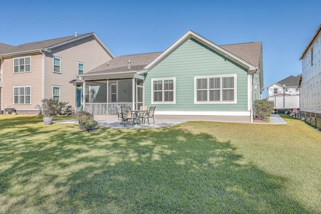 rear view of house featuring a sunroom, a yard, and a patio area