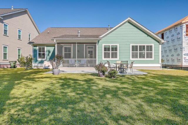 back of property featuring a yard, a patio area, and a sunroom