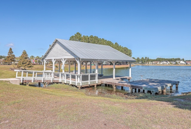 dock area with a gazebo, a water view, and a yard