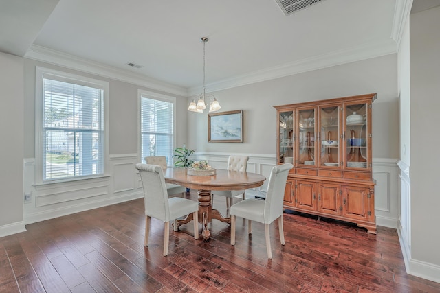 dining space with dark hardwood / wood-style flooring, ornamental molding, and a chandelier