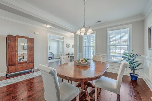 dining room with crown molding, dark wood-type flooring, and a notable chandelier