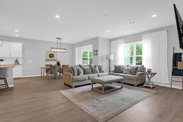 living room featuring visible vents, recessed lighting, baseboards, and wood finished floors