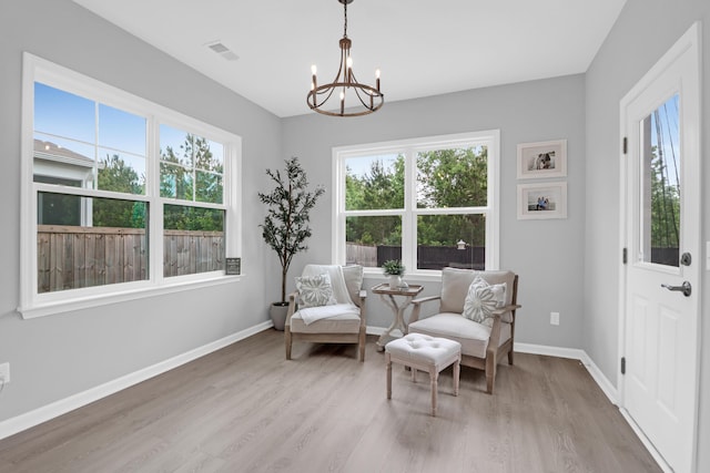 sitting room featuring baseboards, a notable chandelier, a healthy amount of sunlight, and light wood-style flooring