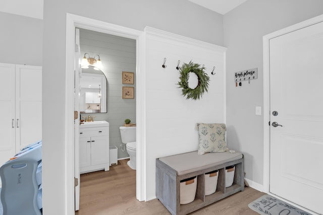 mudroom featuring light wood-style floors and a sink