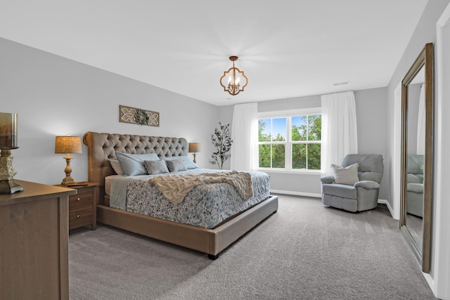 carpeted bedroom featuring baseboards, a notable chandelier, and visible vents