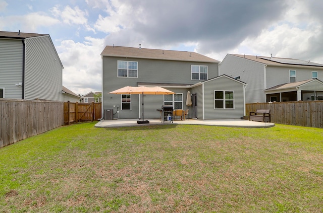 rear view of property featuring a fenced backyard, a patio, and a lawn