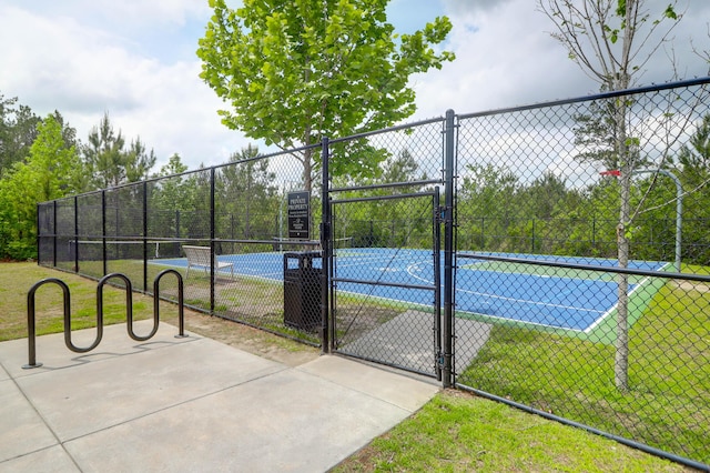 view of sport court featuring fence and a gate
