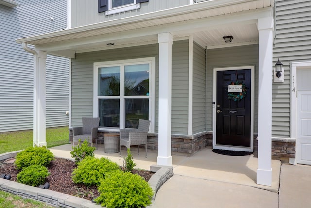 property entrance with a porch and stone siding