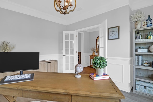 office space featuring a chandelier, ornamental molding, french doors, and a wainscoted wall