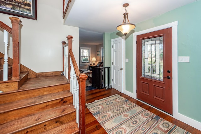 entryway with baseboards, stairway, and wood finished floors