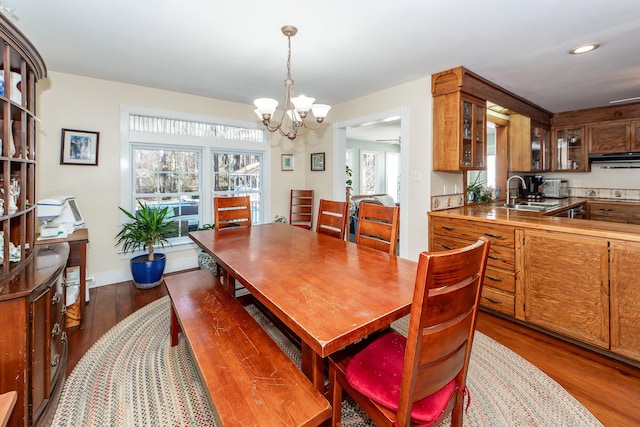 dining area featuring dark wood-style floors, recessed lighting, baseboards, and an inviting chandelier