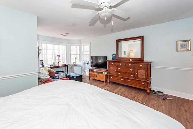 bedroom featuring ceiling fan, baseboards, and wood finished floors