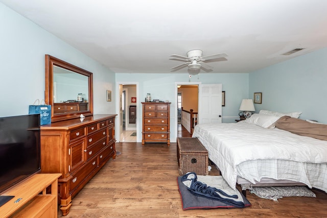 bedroom featuring ceiling fan, wood finished floors, and visible vents