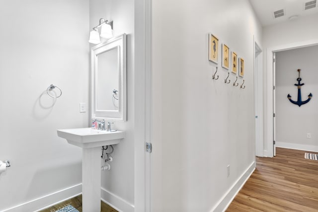 bathroom featuring wood finished floors, visible vents, and baseboards