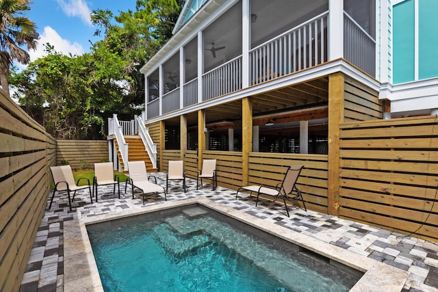 view of swimming pool featuring stairway, fence, a patio, and a sunroom