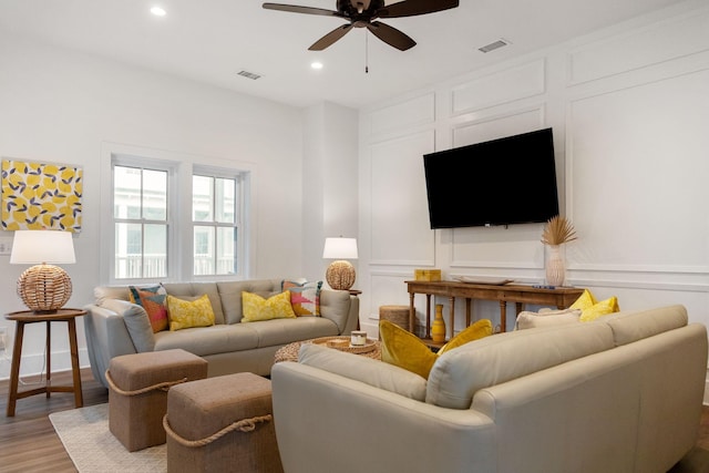 living room featuring visible vents, wood finished floors, recessed lighting, a decorative wall, and ceiling fan