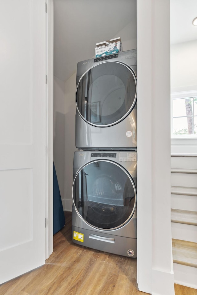 laundry area featuring stacked washer / dryer, laundry area, and wood finished floors