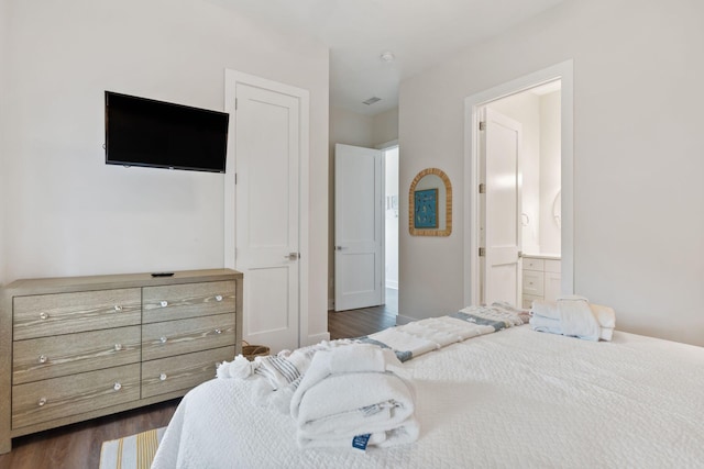 bedroom with dark wood-style floors and ensuite bathroom