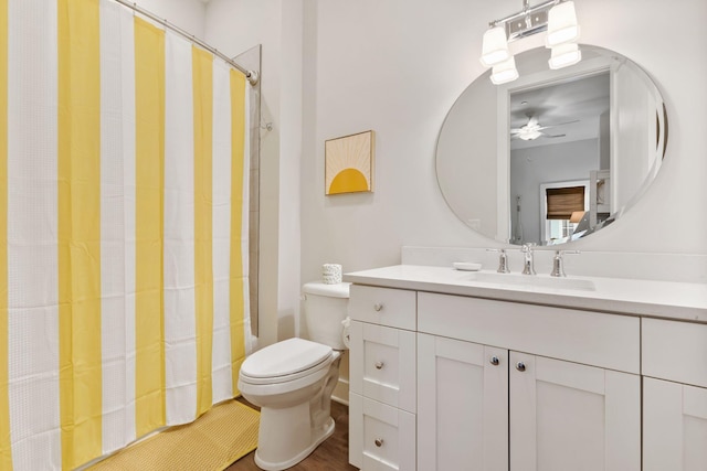 bathroom featuring shower / tub combo with curtain, toilet, vanity, and ceiling fan