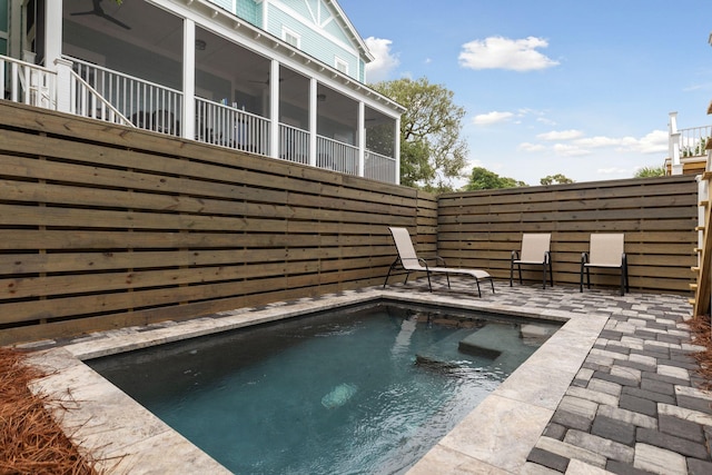 view of pool with a patio, fence, and a sunroom