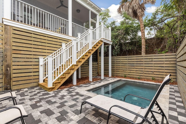 view of pool featuring stairway, fence, an in ground hot tub, a sunroom, and a patio area