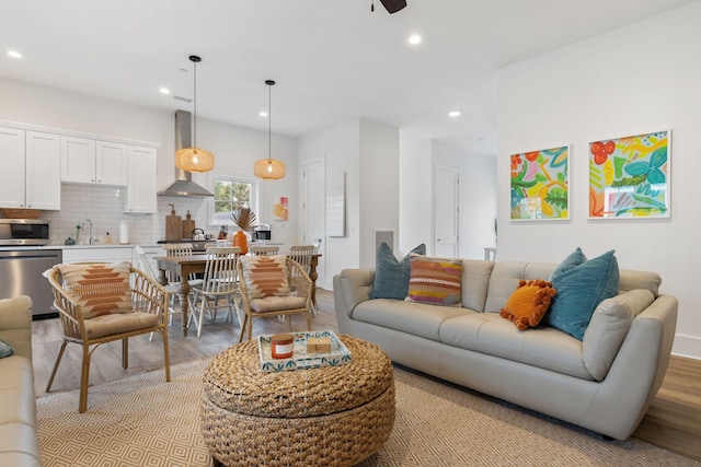 living room with recessed lighting, light wood finished floors, and ceiling fan