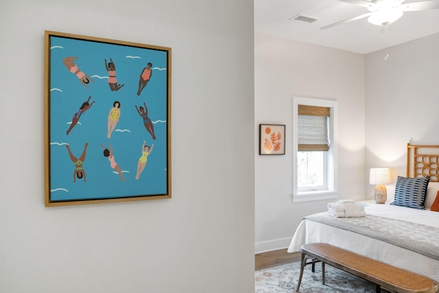 bedroom with visible vents, ceiling fan, baseboards, and wood finished floors