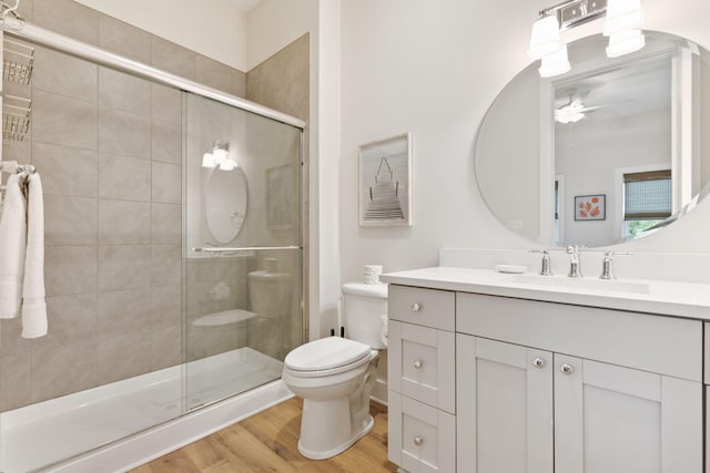 full bathroom with vanity, toilet, wood finished floors, and a stall shower