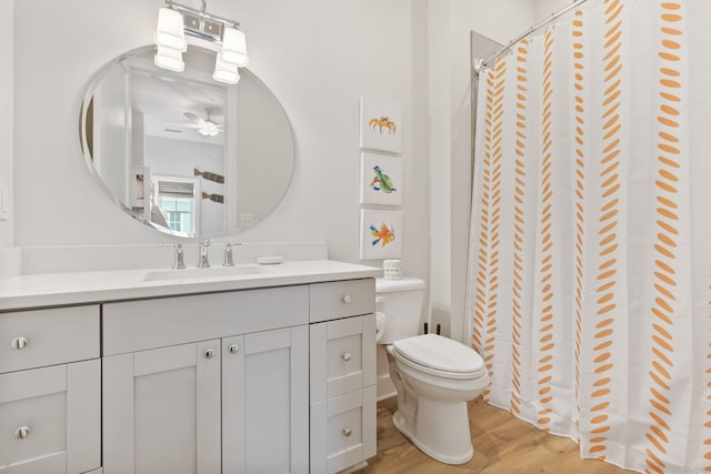 full bath with vanity, a shower with curtain, wood finished floors, a ceiling fan, and toilet