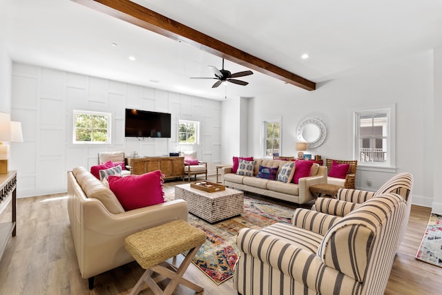 living area featuring a ceiling fan, beam ceiling, recessed lighting, and light wood-style floors