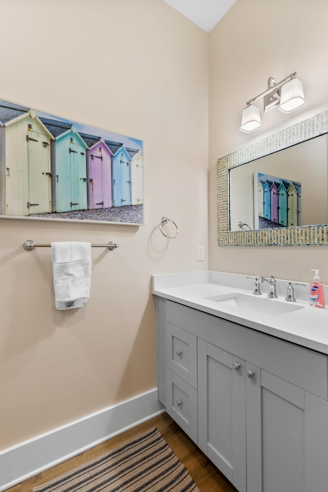 bathroom featuring baseboards, wood finished floors, and vanity