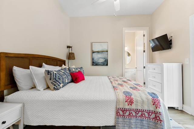 bedroom featuring connected bathroom, baseboards, wood finished floors, and a ceiling fan