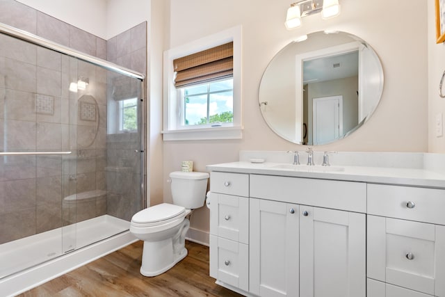 full bath with vanity, toilet, wood finished floors, and a shower stall