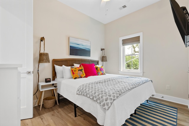 bedroom with visible vents, baseboards, and wood finished floors