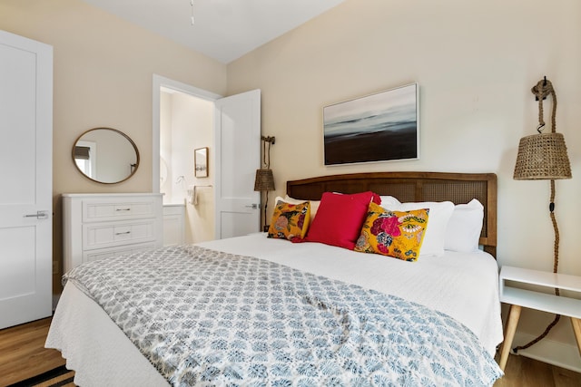 bedroom with ensuite bathroom and wood finished floors