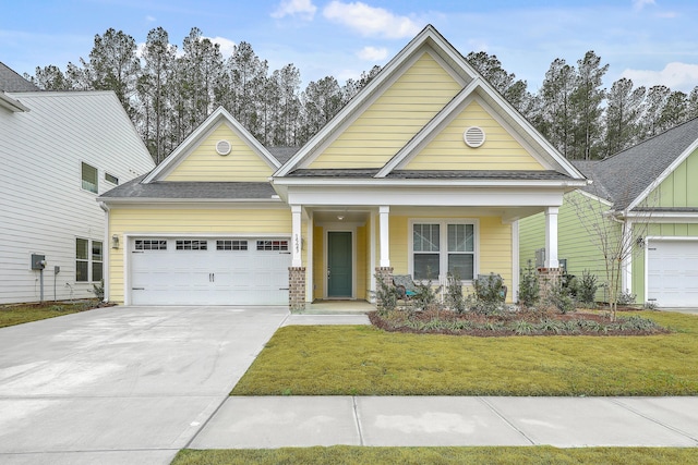 craftsman-style home featuring driveway, roof with shingles, covered porch, a front lawn, and a garage