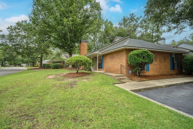 58 Indigo Ln, Goose Creek, SC 29445 - view of property exterior with a chimney, brick siding, a lawn, and a shingled roof