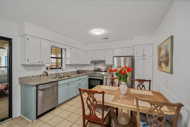 58 Indigo Ln, Goose Creek, SC 29445 - kitchen featuring appliances with stainless steel finishes, a sink, under cabinet range hood, light tile patterned flooring, and a textured ceiling