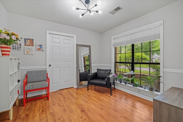 58 Indigo Ln, Goose Creek, SC 29445 - sitting room with a chandelier, light wood-style floors, a textured ceiling, and baseboards