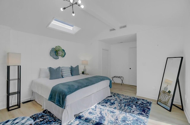 bedroom featuring light wood-type flooring, vaulted ceiling with skylight, and visible vents