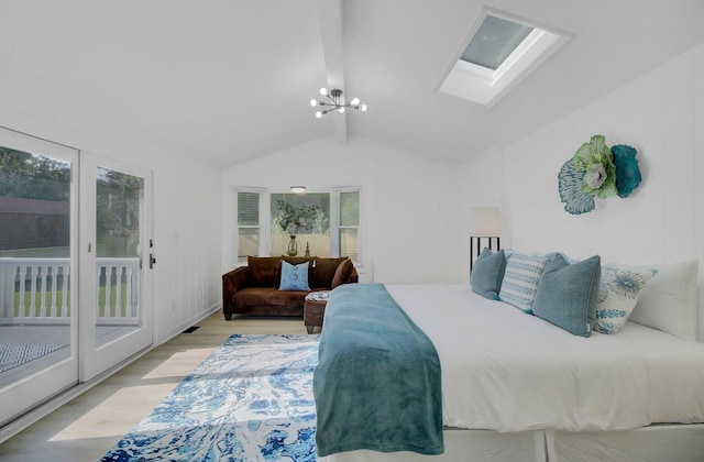 bedroom featuring a chandelier, access to outside, vaulted ceiling with skylight, and wood finished floors