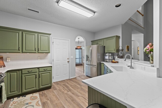 6242 Fieldstone Cir, Charleston, SC 29414 - kitchen featuring green cabinetry, a sink, stainless steel appliances, arched walkways, and light wood-type flooring