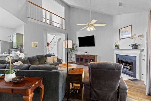 6242 Fieldstone Cir, Charleston, SC 29414 - living area with ceiling fan, a fireplace with flush hearth, light wood-style flooring, stairway, and high vaulted ceiling