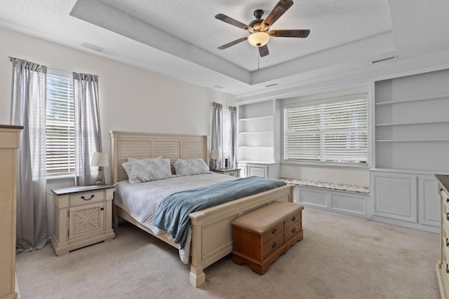 6242 Fieldstone Cir, Charleston, SC 29414 - bedroom with multiple windows, a tray ceiling, light colored carpet, a textured ceiling, and a ceiling fan