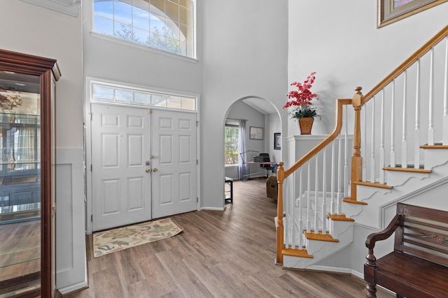 6242 Fieldstone Cir, Charleston, SC 29414 - entryway featuring arched walkways, a towering ceiling, wood finished floors, stairway, and baseboards