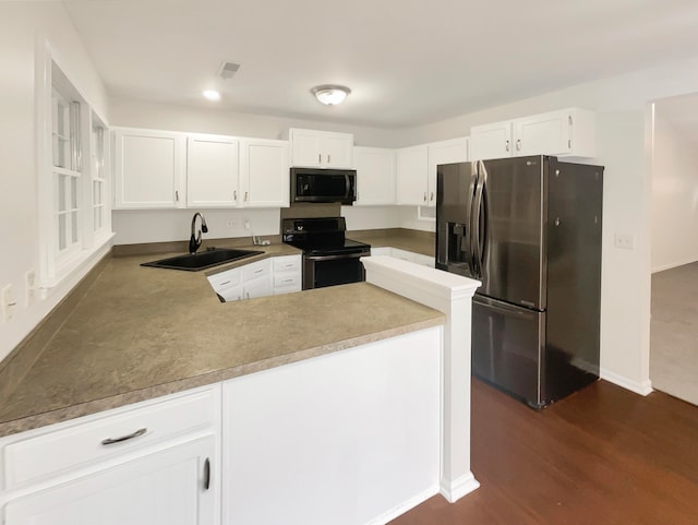 kitchen with sink, white cabinets, kitchen peninsula, appliances with stainless steel finishes, and dark hardwood / wood-style flooring